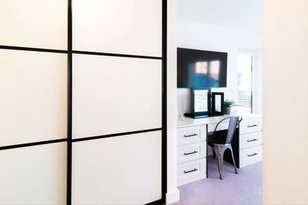 A wardrobe, desk, chair and smart tv